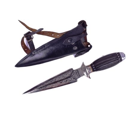 A vintage Indian made dagger with a leather leg holster. The dagger with a round white metal pommel, ribbed horn grip and knu