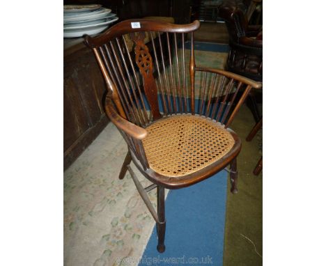 An Arts &amp; Crafts design stick and wheelback Elbow Chair having turned legs and stretchers, stick arm supports and caned s