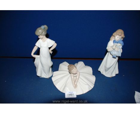 Three Nao figures including a ballerina, girl holding dress and a girl holding a doll.