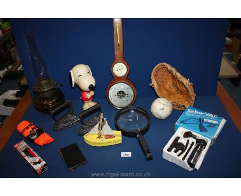 Two flat irons, lamp with glass reservoir, leather barometer, large magnifying glass, baseball glove and ball.