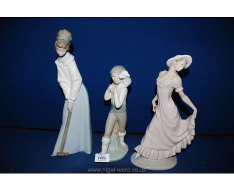 Three Nao figures of a woman playing croquet, woman holding dress and a child carrying a lamb.