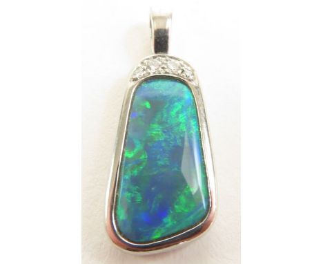 A platinum opal and diamond pendant, the free form opal 17.3mm long (max) x 9.35mm wide (max) x 3mm deep, with four round dia