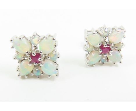 A pair of white opal and ruby stud earrings, overall 9mm square, in white gold marked '14k', 2.5g gross