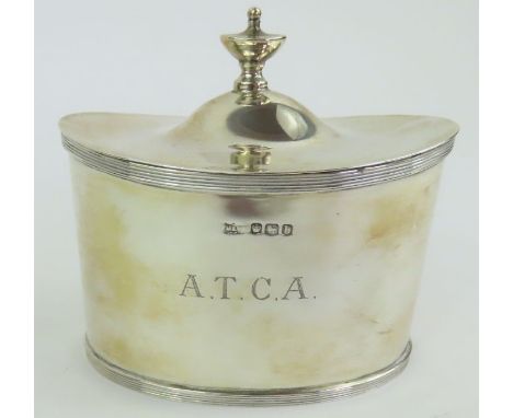 A silver tea caddy in the Georgian style, by Mappin &amp; Webb, Sheffield 1919, of oval outline with a hinged cover with urn 