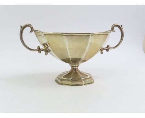 A late Victorian silver sugar basin, by W L &amp; Co, Birmingham 1899, of pedestal panelled form, with scroll handles, approx