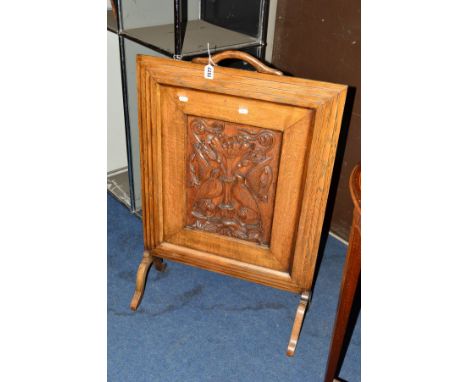 AN EARLY 20TH CENTURY OAK FIRESCREEN with a carved decoration of a pair of doves and foliage