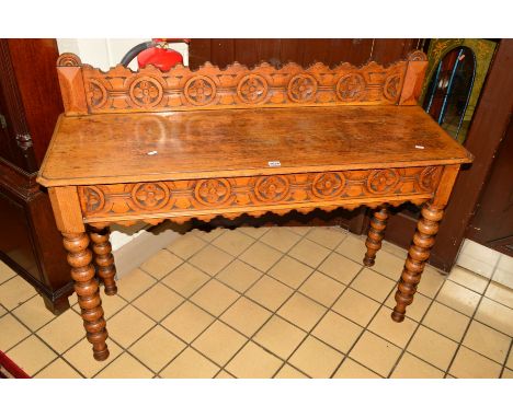 A VICTORIAN OAK SIDE TABLE, the foliate carved back above rectangular top, on bobbin turned legs, width 122cm x depth 41cm x 