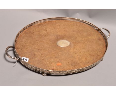 A LATE VICTORIAN SILVER MOUNTED OVAL OAK TWIN HANDLED GALLERY TRAY, the oak with oval silver cartouche engraved with initial 