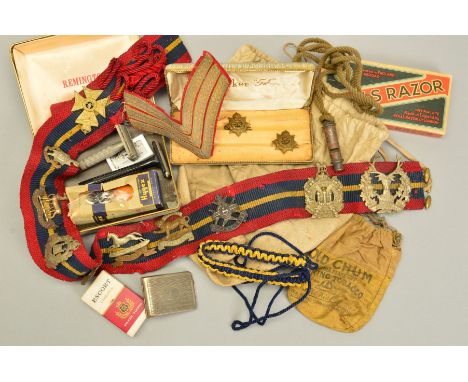 A BOX CONTAINING A CLOTH BELT WITH MILITARY CAP BADGES, affixed ten in number, also including two WWII period mens wet razors