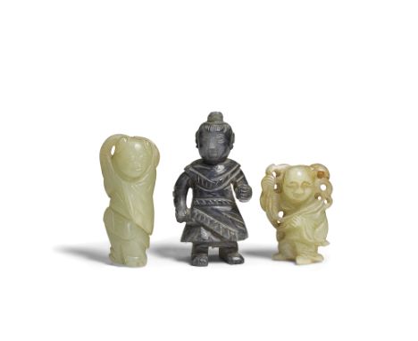THREE JADE 'BOY' CARVINGSLate Qing Dynasty The largest of dark tone, carved clad in a tunic with left hand raised beside his 