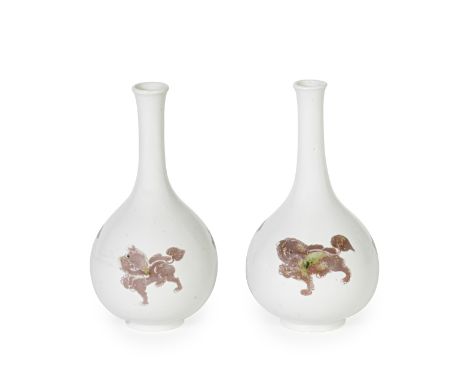 A PAIR OF COPPER-RED 'MYTHICAL BEAST' BOTTLE VASESKangxiEach of globular body rising from a flat short foot to a tall slender