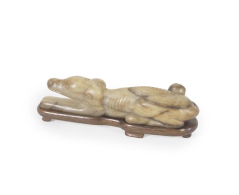 A JADE CARVING OF A HOUNDMing dynastyThe canine resting its head on its outstretched forelegs, with finely incised eyes, nost