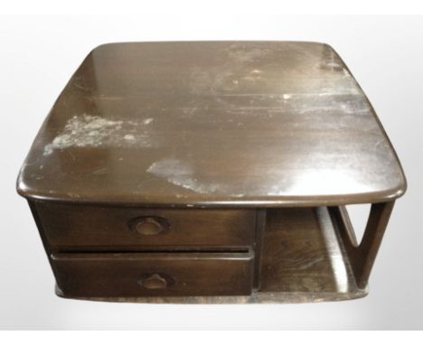 An Ercol dark elm Pandora's box coffee table on castors, 80cm wide x 40cm high. CONDITION REPORT: Water damages to top.