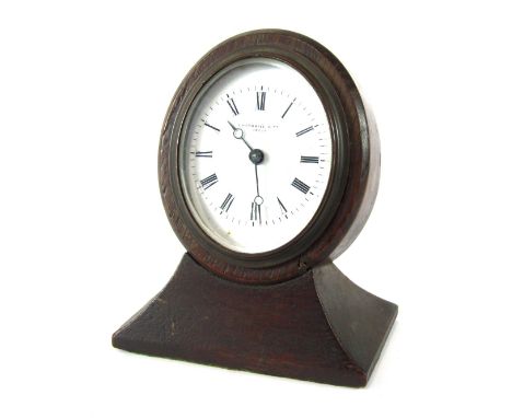 A Thornhill &amp; Co of London desk clock, the shaped oval top with white ceramic dial, bearing Roman numerals and black hand