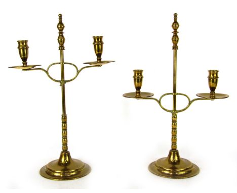 A pair of early 20thC brass candelabra, each with two sconces, on a bobbin stem, on stepped base, 38cm high.