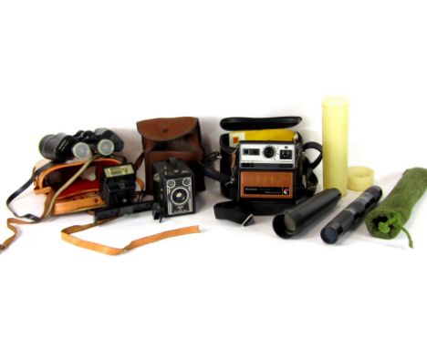 A group of camera and optics equipment, comprising a pair of Yashica binoculars, a Kodak Brownie, a Kodak Instant flash, a Ko