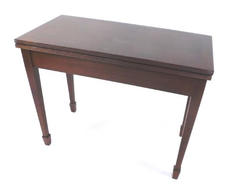 A Georgian style mahogany card table, the fold over top with reeded edge, enclosing a baize interior, raised on square taperi