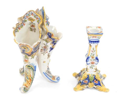 Two items of 19thC faience pottery, comprising a triform cornucopia vase painted with flowers, 20cm high, and a candlestick, 