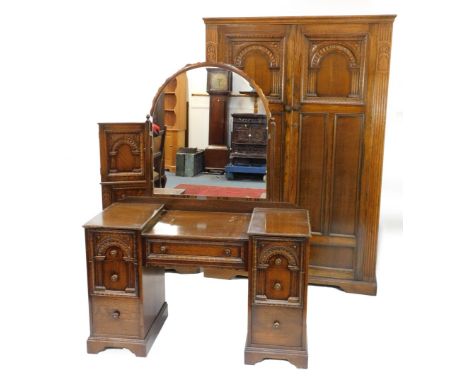 An early 20thC oak bedroom suite, comprising two door wardrobe, chest of drawers, and dressing table, each with reeded and ca