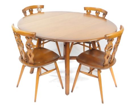 An Ercol light elm and beech kitchen dining table and four chairs, the drop flap table raised on tapering square legs, united