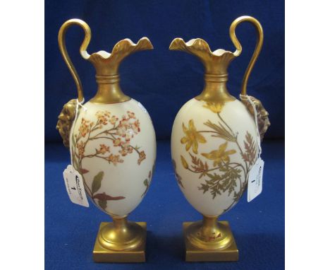 Pair of Royal Worcester ivory ground gilt decorated ewers, overall with foliage and flowers, satire head mounts on pedestal s