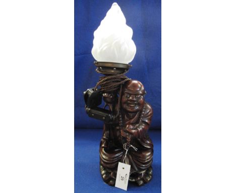 Oriental carved wooden figural lamp base in the form of a seated Buddha with lotus flower and beads, electric fitting with fr