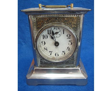 German plated metal mantle clock with repousse panels on bracketed base.  16 cm high approximately.(B.P. 24% incl. VAT)