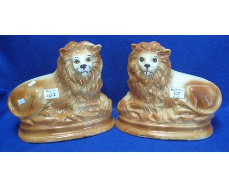 Pair of late 19th Century Staffordshire pottery recumbent Lions with glass eyes.  (2)(B.P. 24% incl. VAT)   CONDITION REPORT: