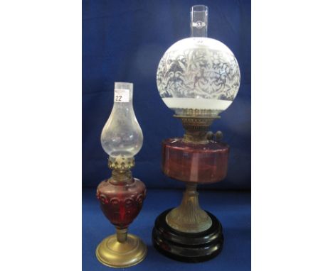 Late Victorian brass double burner oil lamp with cranberry glass reservoir, ceramic base, etched glass shade and clear chimne