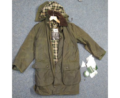 A Barbour long wax jacket with hood in Border jacket style, complete with original labels, guarantee leaflet and a tin of Bar