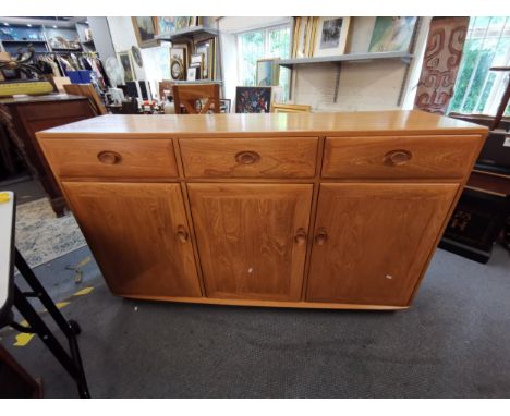 A modern Ercol sideboard with three drawers over three cupboard doors, raised on plinth base, 94 h x 115 w x 44cm dLocation: 