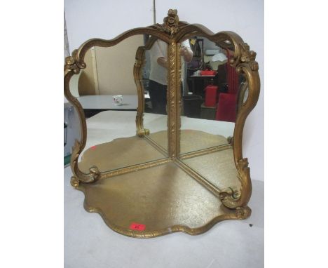 A vintage corner mirror, freestanding with triangular base, scrolled side supports with a central rose, all in gilt coloured 