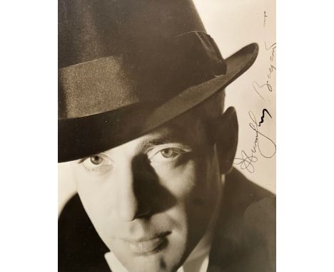 Humphrey Bogart (1899-1957) – A framed black and white photograph signed by Humphrey Bogart in black ink “Humphrey Bogart”. B