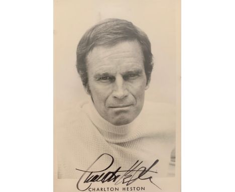 Charlton Heston (1923-2008) – A framed black and white photograph signed by Charlton Heston in black pen “Charlton Heston”. P