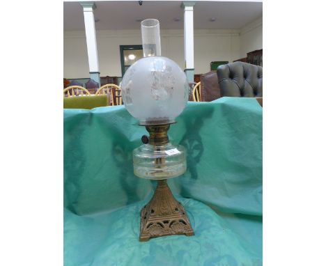 Oil lamp with etched domed glass shade on a gilded metal plinth