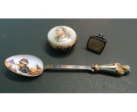 A silver gilt and enamel decorated teaspoon with an Egyptian theme, the finial opening to reveal a mummy in yellow metal, tog