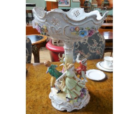 A Continental porcelain table centre of imposing proportions, the circular bowl over stylized tree trunk column, surrounded b