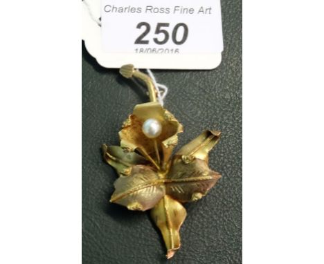 A stylized foliate brooch, the central flower head with cultured pearl to centre, above symmetrical leaves and an engraved st