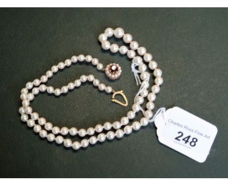 A graduated single row cultured pearl necklace to a 9 carat gold garnet and pearl cluster drop.