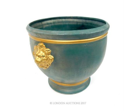 A large painted ceramic planter, parcel gilt, with lion mask handles on a green ground, 34 x 44 x 37cm.