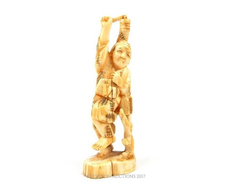 A late 19th century carved Chinese ivory figure of a gentleman perched by a tree stump, carrying tools in both hands, height 