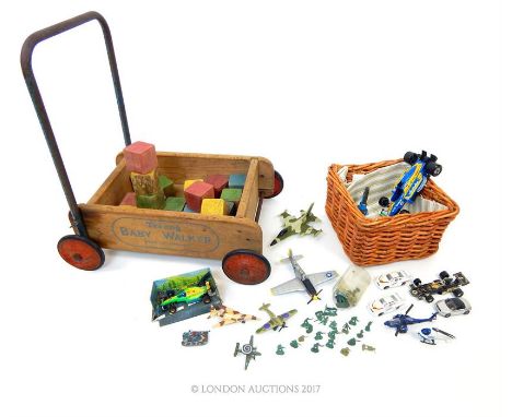 A vintage, 1950's Tri-Ang wooden baby walker on wheels containing painted wooden blocks (50 x 47 x 35 cm) with a wicker baske