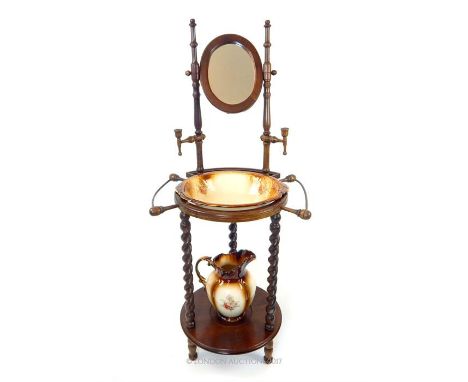 A Continental beech washstand, with an oval adjustable mirror and candle holders, raised on barley twist supports joined by a
