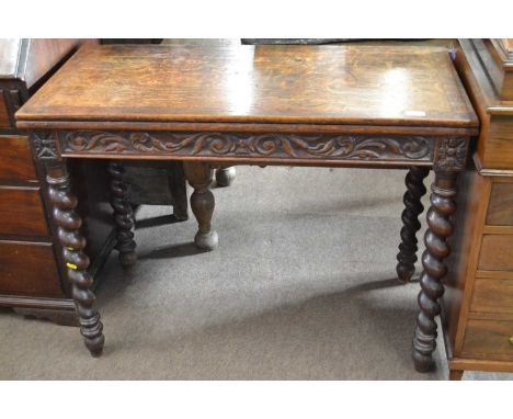 A Victorian oak card table with fold over baize lined top raised on barley twist legs, 100cm wide