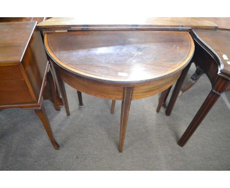 A Georgian mahogany demi lune card table with inlaid decoration with hinged top opening to a baize lined interior raised on t
