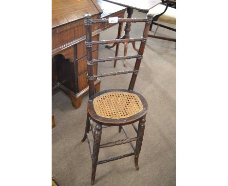 A Victorian mahogany framed correction chair, the ladder back over an oval cane seat and a bobbin turned base, 97cm high, 31c