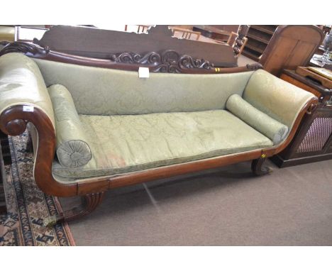 A large late Georgian mahogany framed scroll end sofa, the back with carved pediment, upholstered in a green fabric with loos