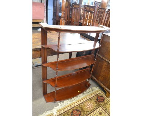 A late 19th Century mahogany bow front wall mounted four shelf cabinet with turned supports, 96cm wide