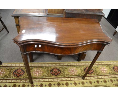 A Georgian mahogany card table of serpentine form, the folding top opening to a green baize lined interior, 87cm wide