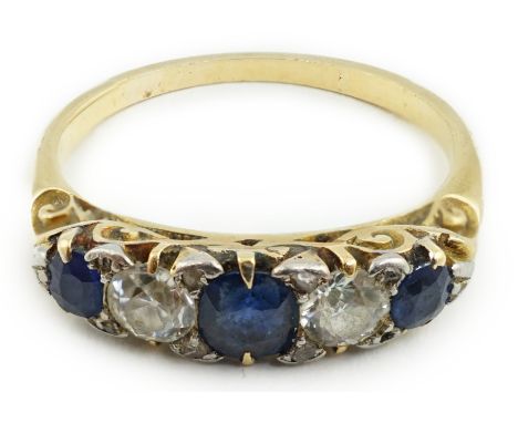 A gold, three stone sapphire and two stone diamond set half hoop ring, with diamond chip spacers, size M/N, gross weight 2.9 